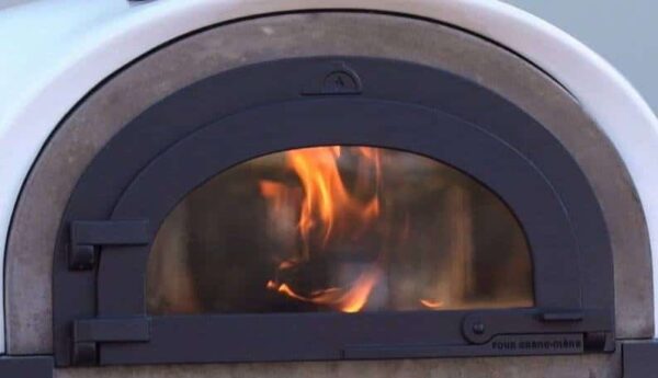 Brennendes Holzfeuer in einem Four Grand Mere Alfred Pizzaofen