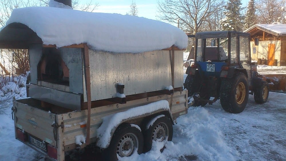Ein mobiler Pizzaofen im Winter mit Schnee drauf