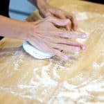 Ein Pizzateig wird von Hand geknetet