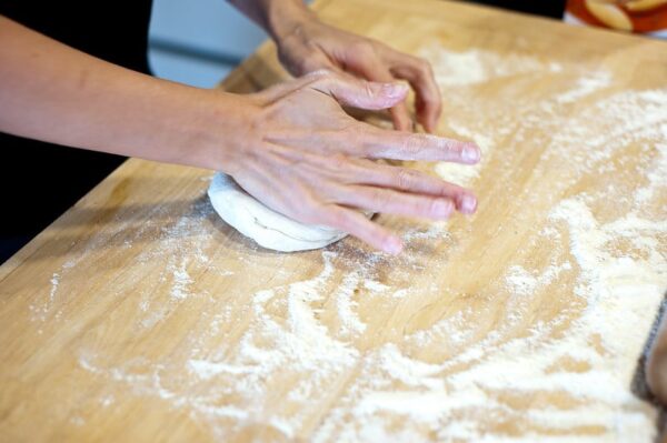 Ein Pizzateig wird von Hand geknetet